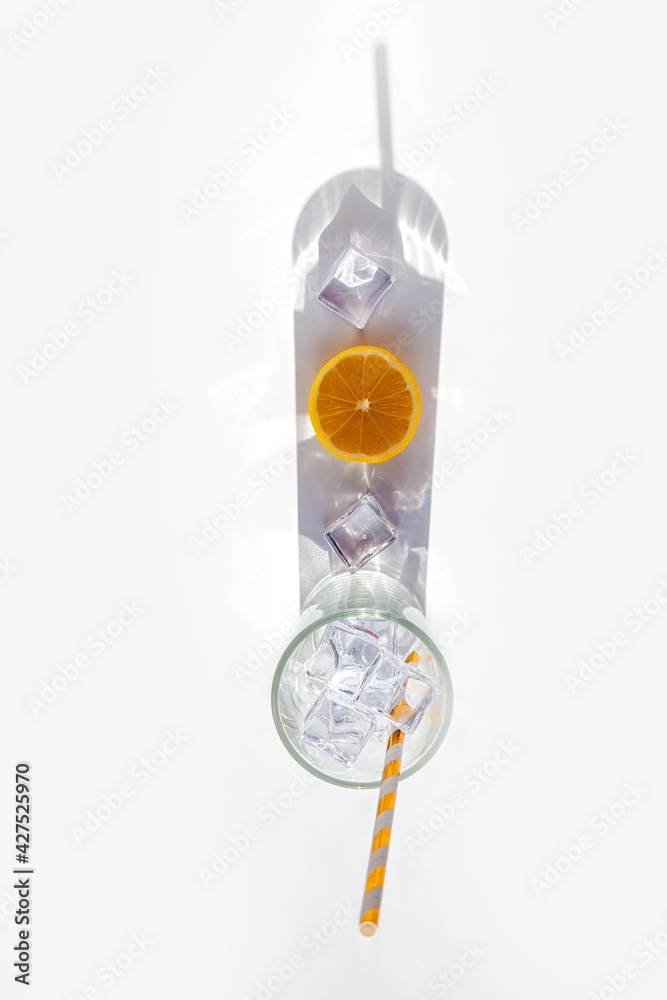 Empty glass with a big shadow that mimics a citrus cocktail. The concept of a summer refreshing cool drink Empty glass with a big shadow that mimics a citrus cocktail. The concept of a summer refreshing cool drink
