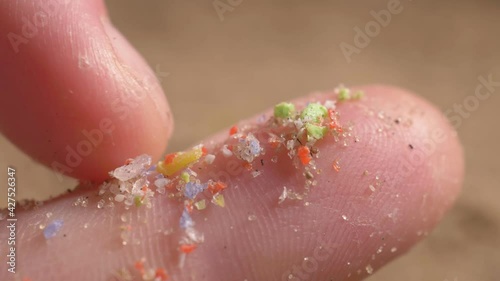 pieces of microplastic on the finger. primary and secondary microplastics. small plastic pellets in human hands. soil contamination, marine plastic pollution, environment, ecology, earth photo
