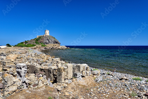 Excavations with an old tower in the background near the town of Nora on the island of Sardinia photo