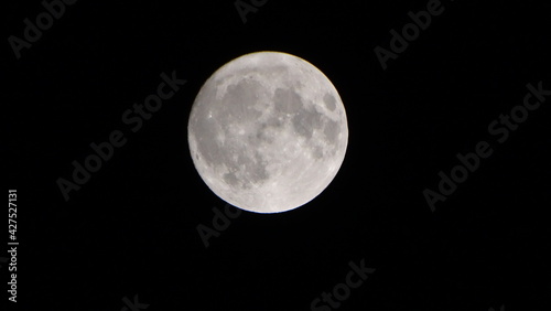 White full moon in dark starless night. Luna llena blanca en noche oscura sin estrellas.