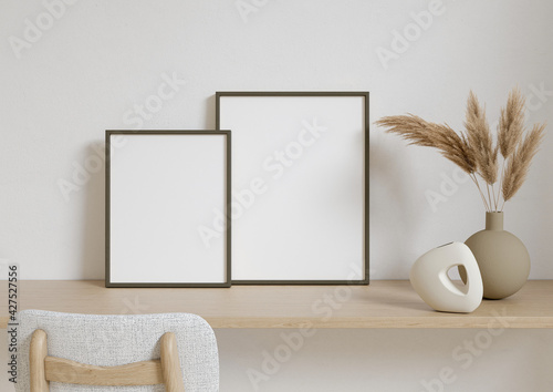 Double 8x10 Vertical Black Frame mockup on a wooden desk with dry plant in vase. 3D Rendering