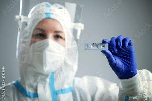 Doctor or nurse in protective face mask and gloves holding negative COVID-19 test. Diagnosis of coronavirus, Inhibition of disease outbreaks.