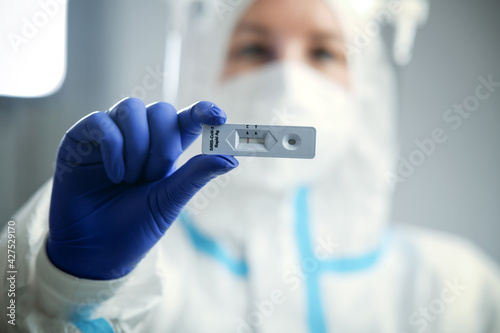 Doctor or nurse in protective face mask and gloves holding negative COVID-19 test. Diagnosis of coronavirus, Inhibition of disease outbreaks.