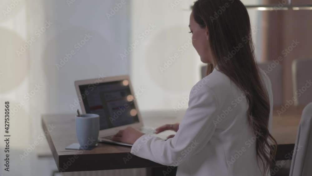 Frau arbeitet am Laptop und trinkt Kaffee