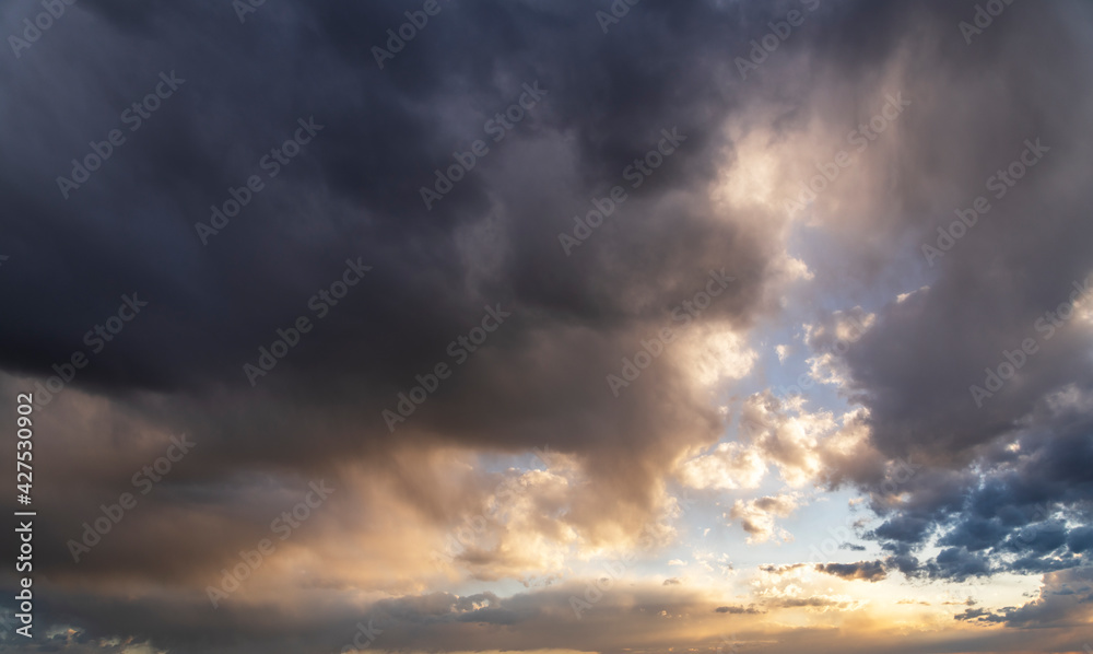 Obraz premium Sunset sky background. Beautiful sunset after rain, with bright orange dramatic clouds.