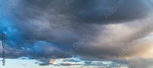 Sunset sky background. Beautiful sunset after rain, with bright blue dramatic clouds.