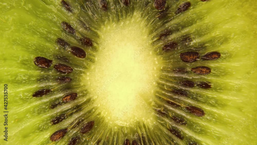 Macro details of a kiwi slice rotating top view.Macro food.Looped rotation.Healthy eating concept.Organic fresh harvest.healthy food,bio food.Green fruit. Macro details of a kiwi slice rotating top view.Macro food.Looped rotation.Healthy eating concept.Organic fresh harvest.healthy food,bio food.Green fruit.