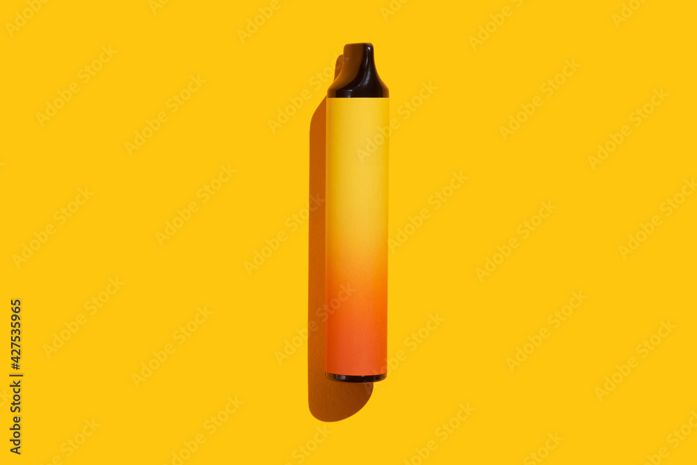 Disposable e-cigarette on yellow isolated background. The concept of modern smoking, vaping and nicotine. Top view Disposable e-cigarette on yellow isolated background. The concept of modern smoking, vaping and nicotine. Top view