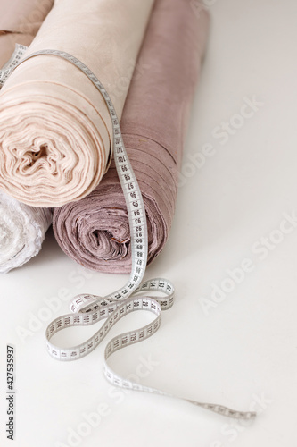 rolls of cloth with an inch on the white table. seamstress