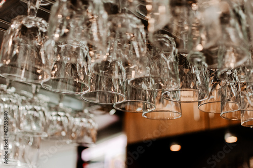 Clean wine glasses hanging on a bar rack at a restaurant