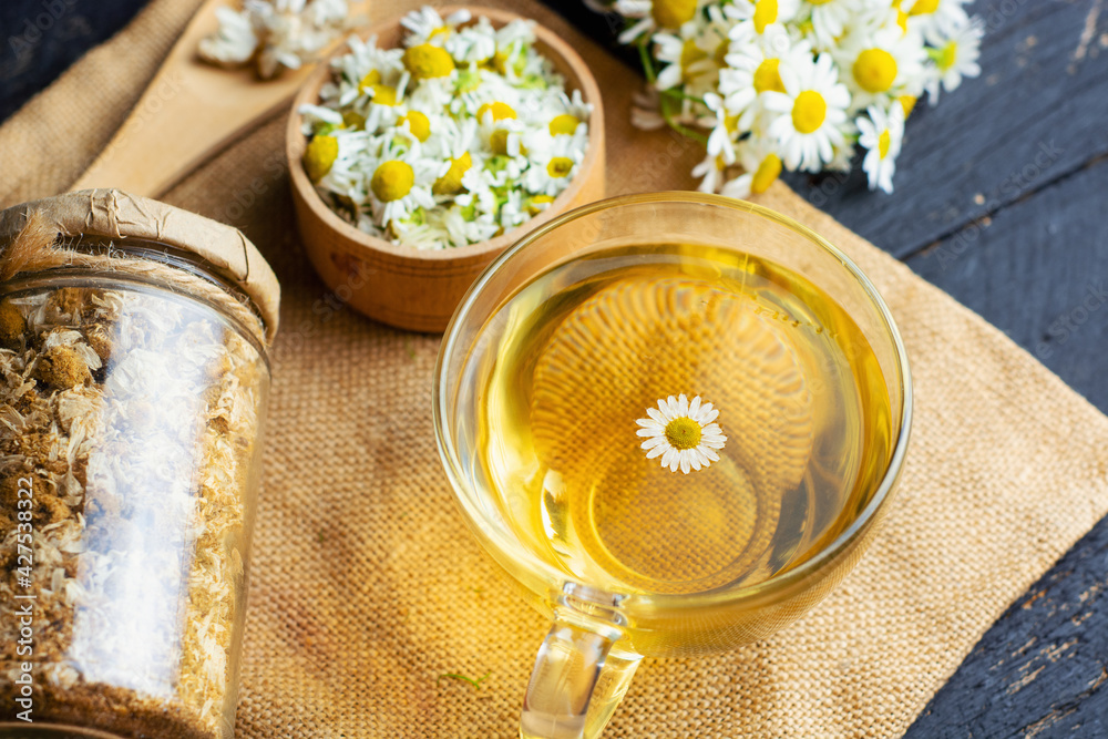 cup of herbal chamomile tea with fresh daisy flowers background, treatment and prevention of immune concept, medicine - folk, alternative, complementary, traditional medicine