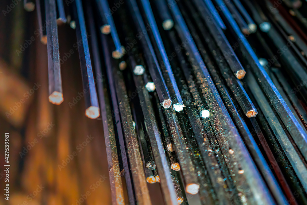 metal rods in mass in a warehouse, end view, metallurgy, steel, blurred background metal rods in mass in a warehouse, end view, metallurgy, steel, blurred background
