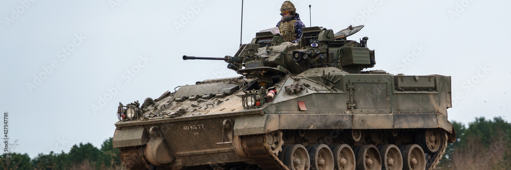 british army FV510 warrior light infantry fighting vehicle tank in action on a military battle exercise, Wiltshire UK