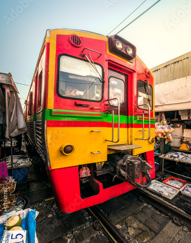 Obraz na płótnie A Train on Umbrella Fresh Market on the Railroad Track, Mae Klong Train Station, Bangkok, Thailand on a Sunny Day w salonie