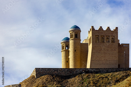 An ancient fortress on a hillside against the sky in the mountains. photo