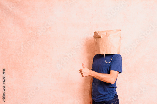 Man with paper bag on his head satisfied with his personal achievement, isolated.