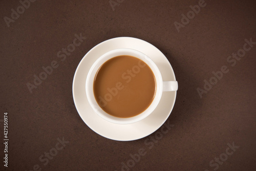A cup of coffee isolated on brown background, top view