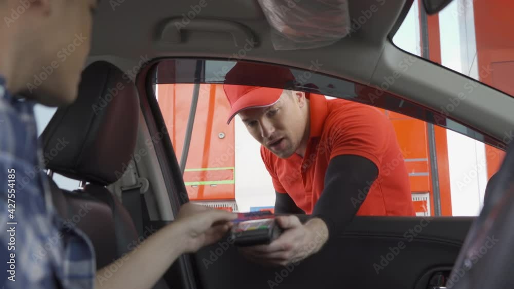 A caucasian man people worker collecting gas bill payment by using EDC machine with a credit card at gasoline petrol station, an online payment option refuel oil and energy vehicle business service.