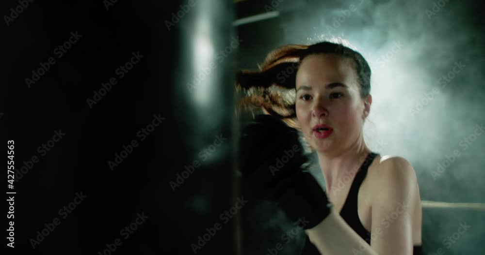Boxer girl getting ready for training. The boxer warms up in the ring, rope, plank, stretching, warms up the muscles. A boxer hits punching bag in the ring. Motivational sports video. Boxer girl getting ready for training. The boxer warms up in the ring, rope, plank, stretching, warms up the muscles. A boxer hits punching bag in the ring. Motivational sports video.