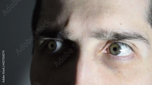 Scared man wakes up, hears strange noises at home at night and looks all around. Unsafe home, insecurity concept