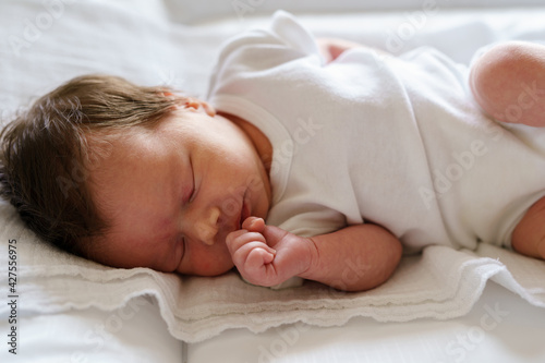 full length newborn two weeks old caucasian baby sleeping in bed at home - cute little infant girl sleep peacefully