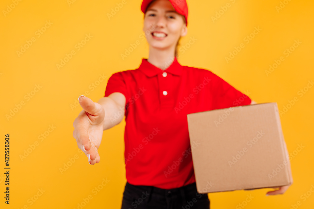 delivery in a red uniform holds a box of a parcel, on a yellow background,