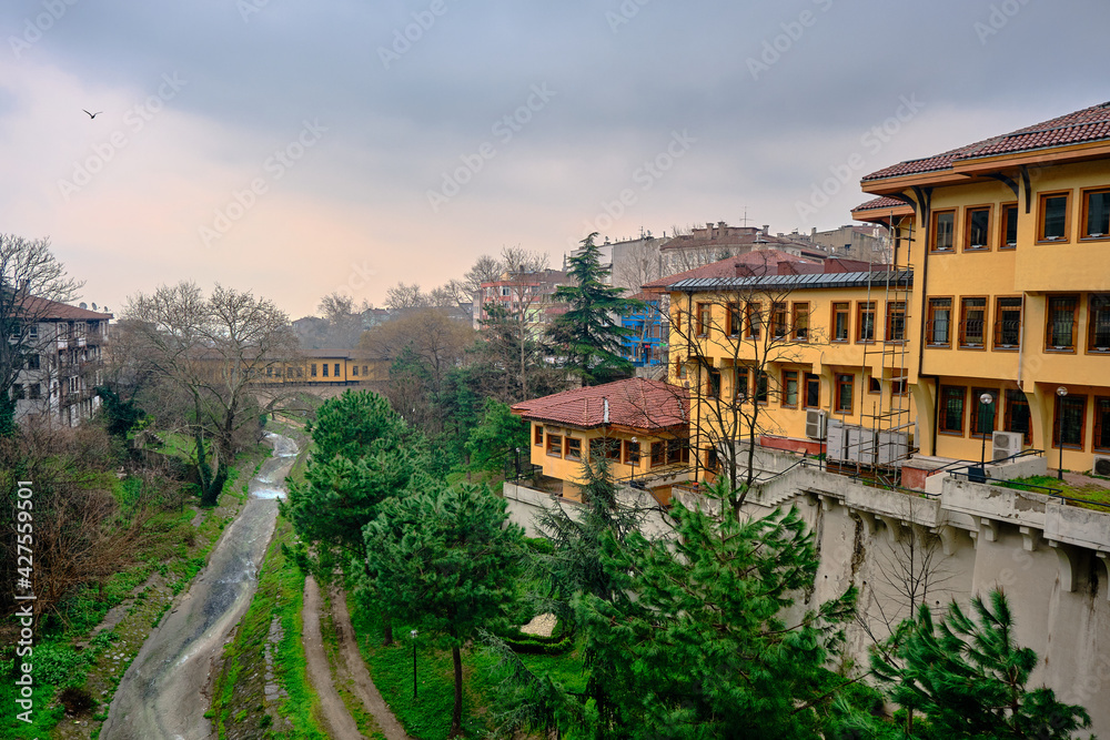 29.03.2021. Bursa Turkey. irgandi bridge and city library in bursa with yellow color painting. Photo taken rainy day and overcast sky including river coming from ulu mountain (uludag)