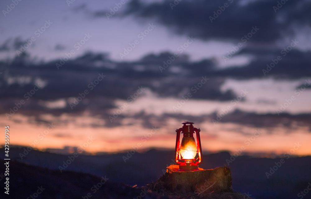 kerosene lamp lit with the sunset sky with the sky just after sunset in the. Concept of faith, religion and hope.
