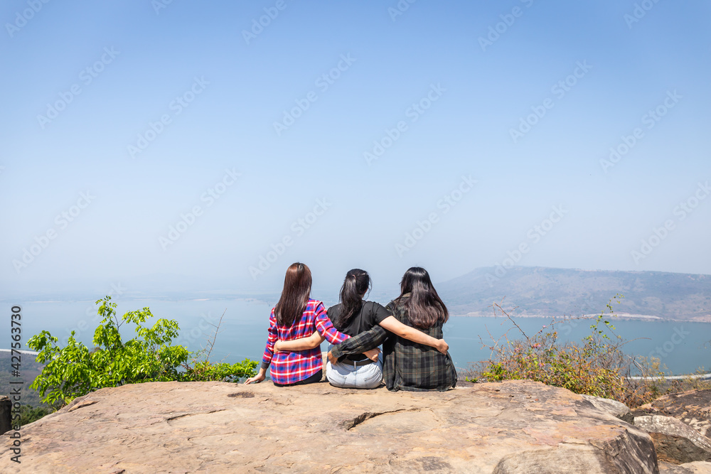 Freedom traveler group of woman sitting on mountain and embrace enjoying a beautiful nature