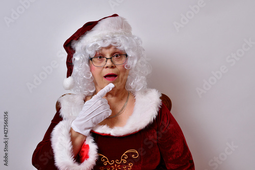 Фотография American female Claus with a thoughtful look planning for a great Christmas