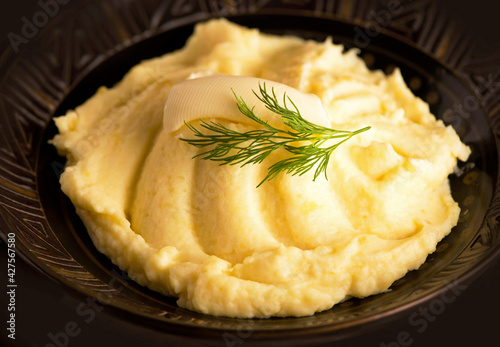 Mashed potatoes in bowl on wooden table.