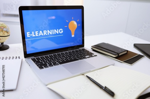 E-learning Education Internet Networking . Young businesswoman sitting at table used laptop with inscription on screen e-learning. Online education e-learning.