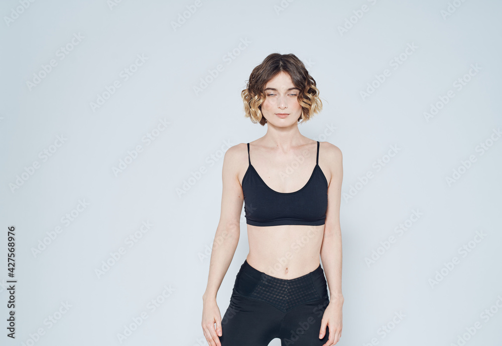 Woman in leggings doing exercises on a light background cropped view of fitness gymnastics Woman in leggings doing exercises on a light background cropped view of fitness gymnastics