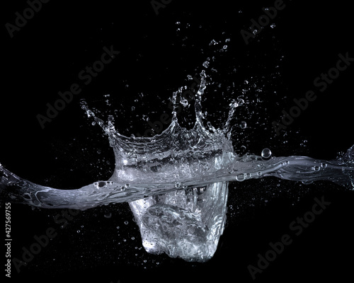 水面に氷を落とした瞬間の水しぶきのテクスチャー。 黒い背景 © hanahal
