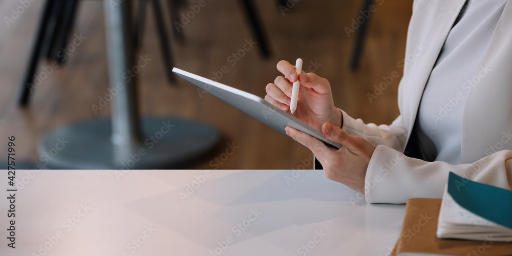 Obraz premium Close up businesswoman holds pen stylus drawing on digital tablet on workplace