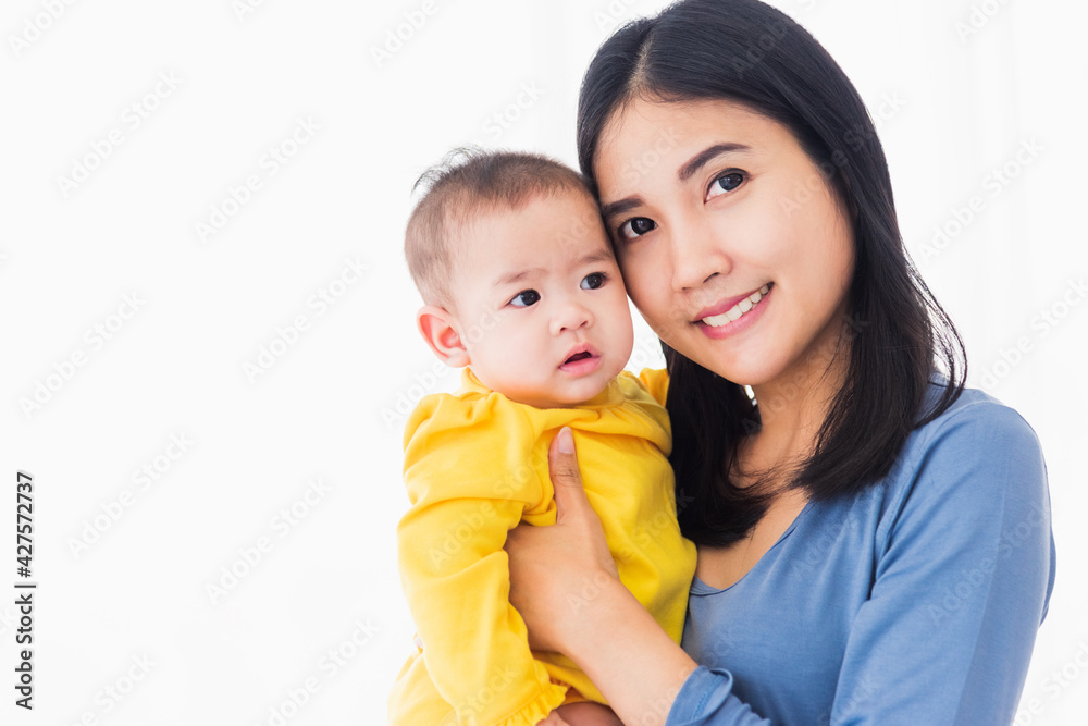 Portrait of beautiful young Asian mother holding his newborn little baby in her arms at home, Parent mom hugging her newborn child, happy family Portrait of beautiful young Asian mother holding his newborn little baby in her arms at home, Parent mom hugging her newborn child, happy family