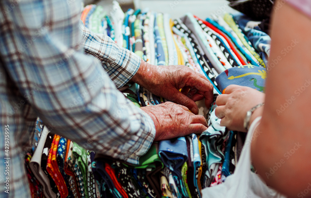 midsection of two people searching for fabric in market store