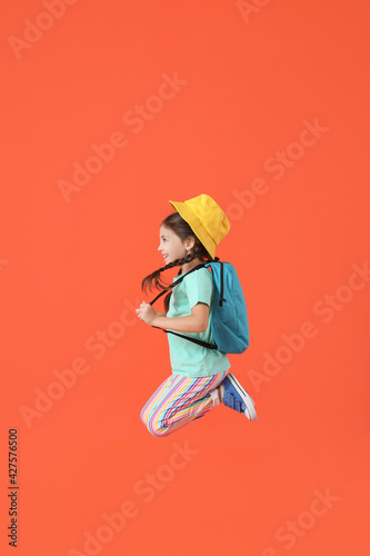 Jumping little girl with ba...