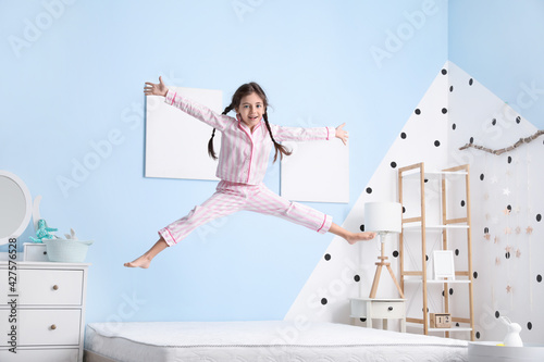 Funny little girl jumping o...