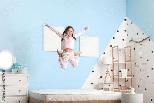 Funny little girl jumping o...