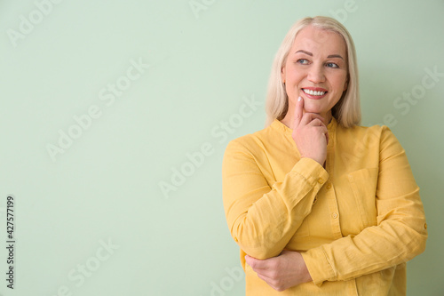 Beautiful mature woman on color background