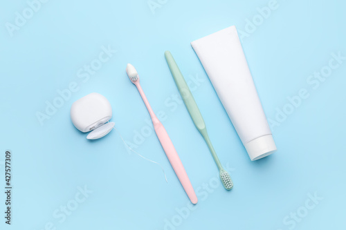 Tooth brushes with paste and dental floss on color background © Pixel-Shot