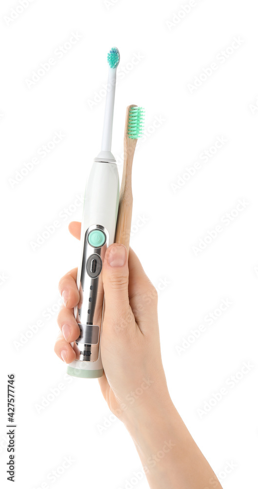 Female hand with different tooth brushes on white background Female hand with different tooth brushes on white background