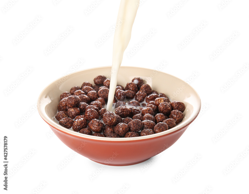 Pouring of milk into bowl with chocolate corn balls on white background Pouring of milk into bowl with chocolate corn balls on white background
