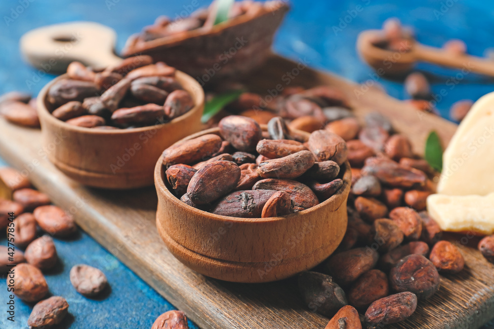 Bowls with cocoa beans on color background Bowls with cocoa beans on color background