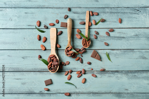 Composition with cocoa beans on color wooden background