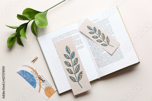 Book with bookmarks and branch on light background photo