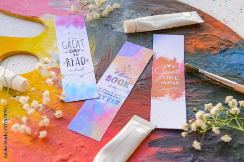 Artist's supplies, bookmarks and flowers on light background, closeup