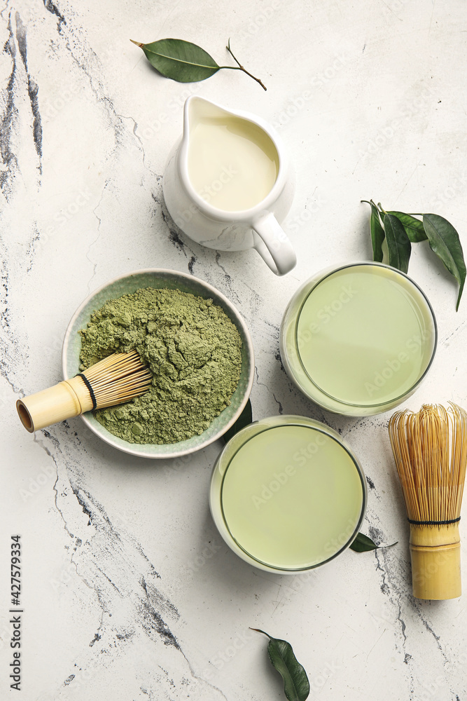 Composition with glasses of matcha tea and powder on light background Composition with glasses of matcha tea and powder on light background