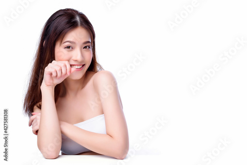 Portrait of beautiful charming young Asian woman posing facial and sitting with white table, beauty of female face with skincare on white background, healthcare and skin care concept.